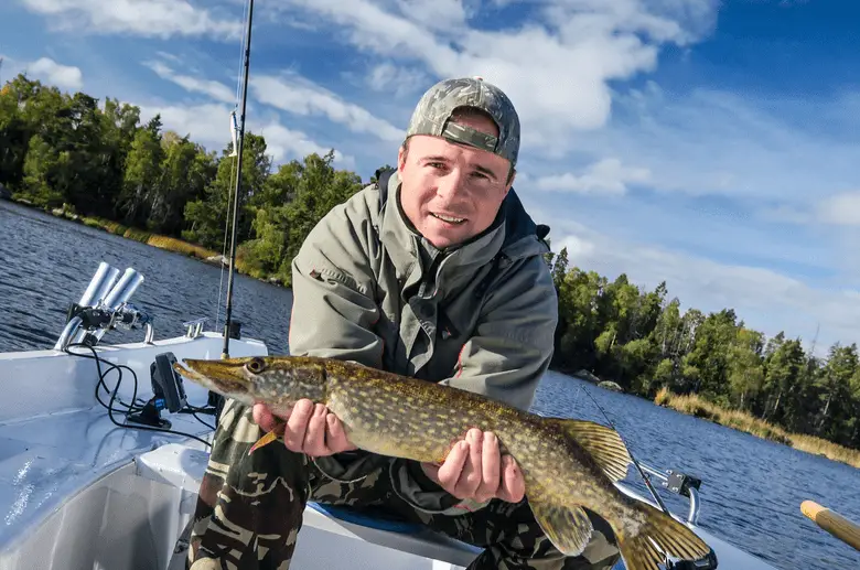 Man with autumn lake pike