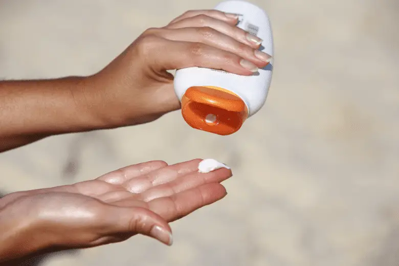 A picture of someone putting sunscreen on their hand