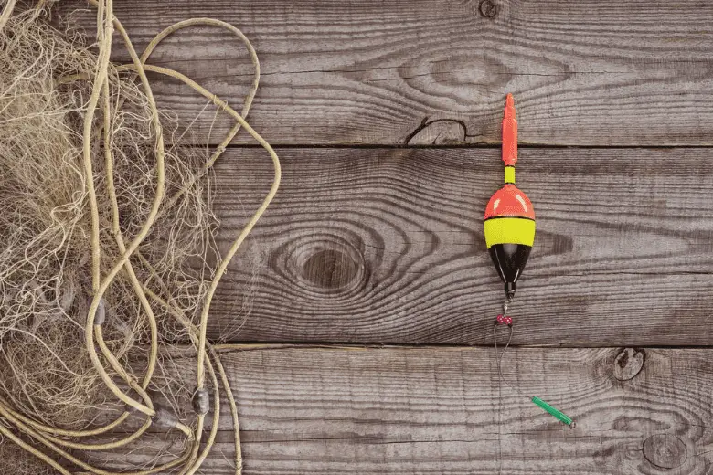 Top view of fishing float and fishing net on wooden background