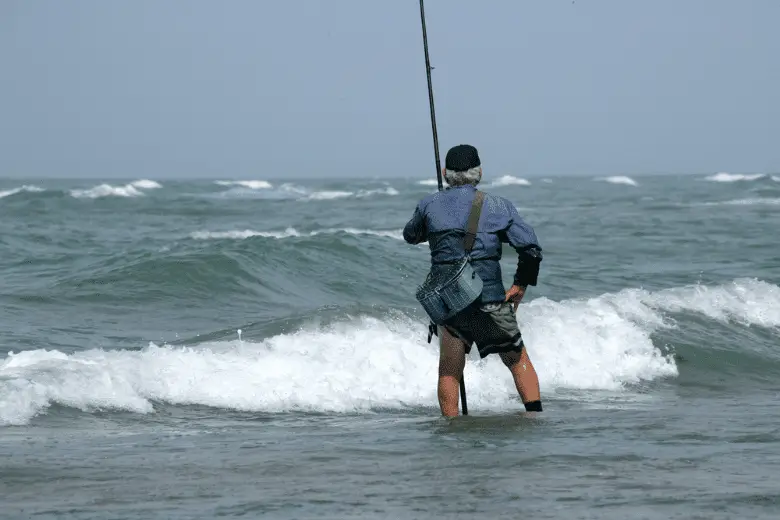 Old man fishing in the sea by the beach