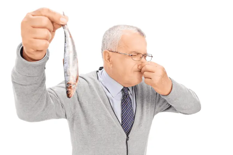 Senior gentleman holding rotten fish