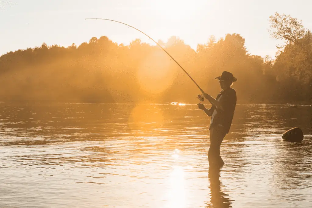 Fisherman on lake at sunset