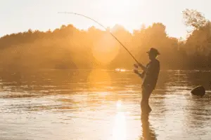 Fisherman on lake at sunset
