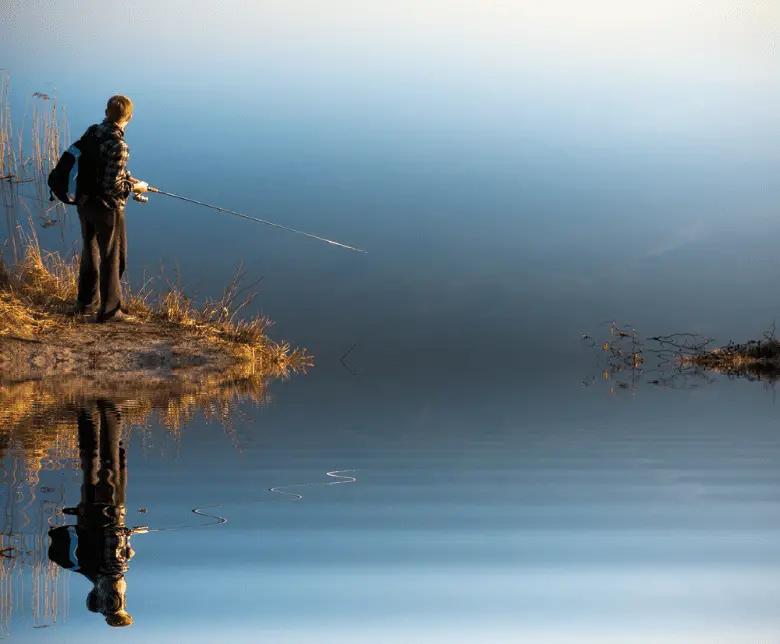 man casting fishing line into a lake