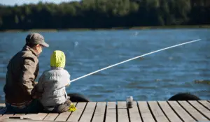 Father and son fishing by a lake