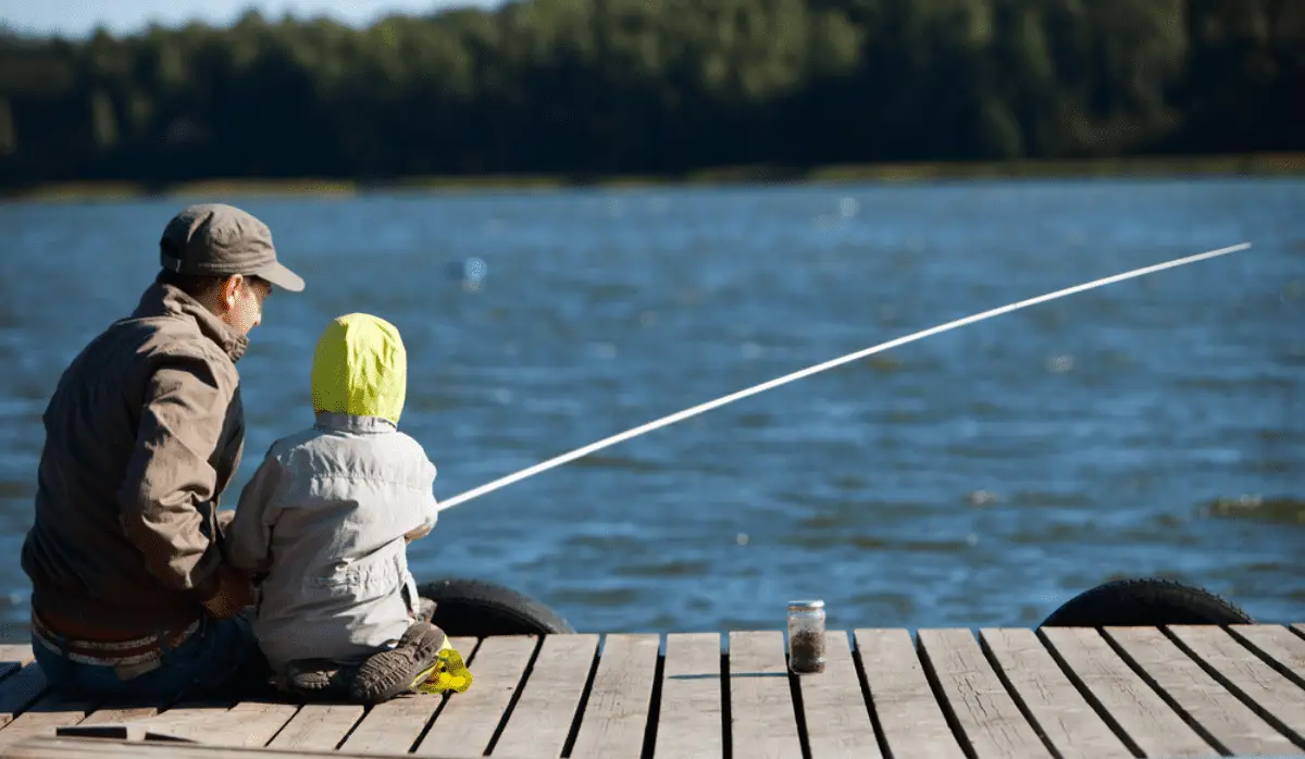 Father and son fishing by a lake