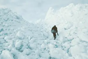 Fisherman walking with ice fishing equipment