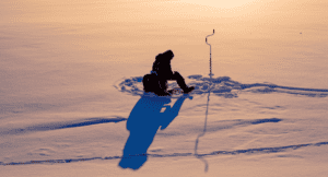 Ice fisherman fishing in the winter on the river
