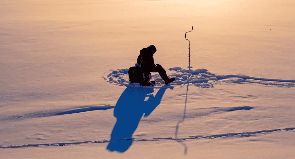 Ice fisherman fishing in the winter on the river