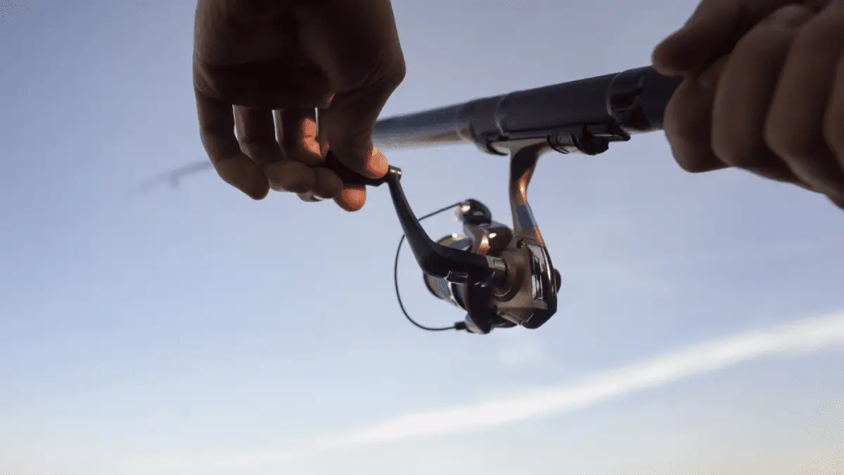 Mans hands on a spinning fishing reel