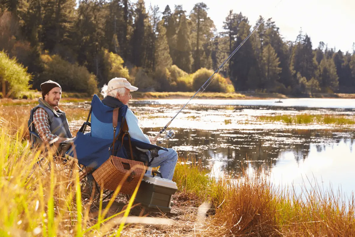 Father and adult son fishing lakeside