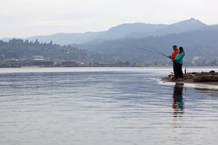 Two men fishing at the bank of a river