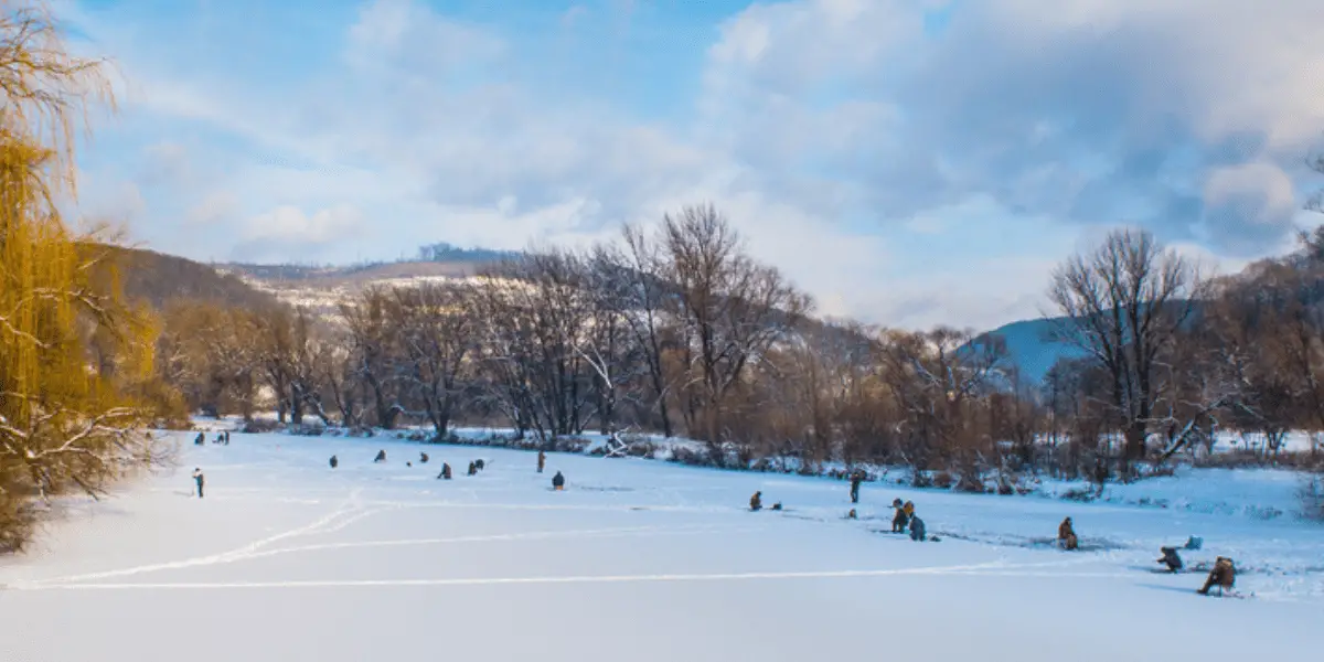 People Ice fishing on a frozen river