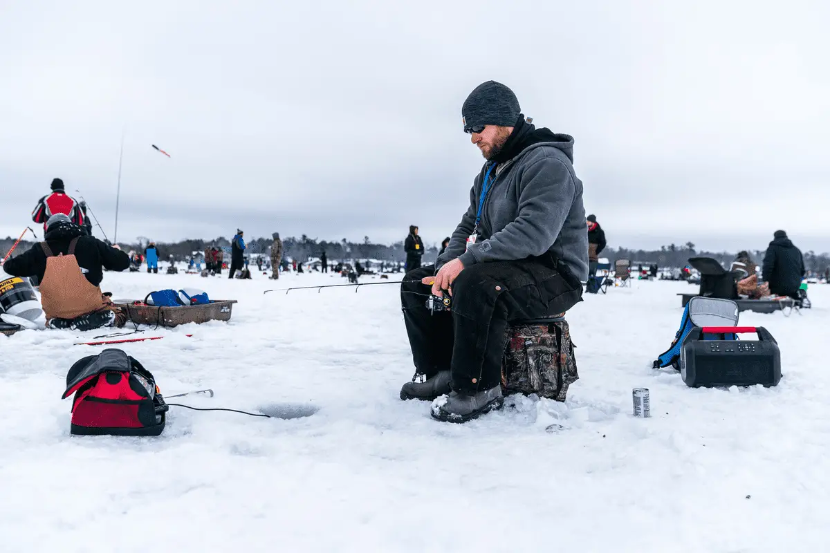 man using a fish finder to locate fish while ice fishing