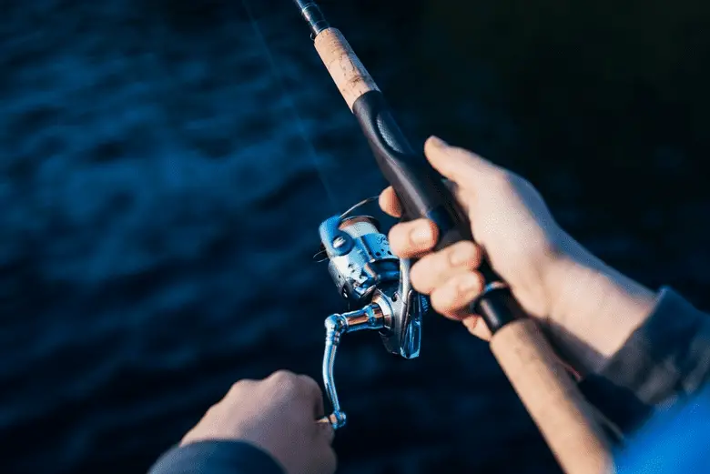close-up shot of a person spinning a fishing reel