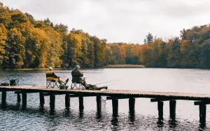 two friends fishing at a lake dock