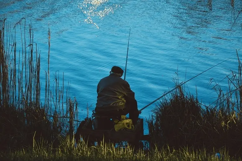 back view of an older man fishing by the river