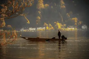 man fishing on a fishing boat in the lake on a sunny day