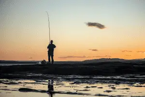 angler fishing at sunset