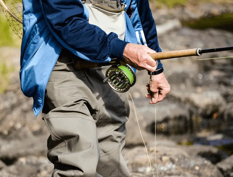 fisherman holding a fishing rod and reel