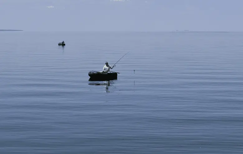 angler in a fishing boat in the middle of the lake