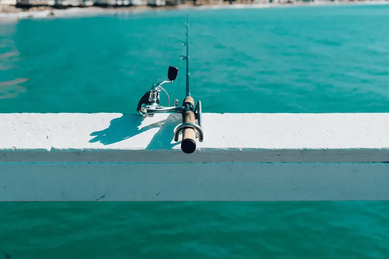 close-up shot of a fishing reel resting on a bench