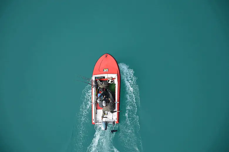 birds-eye view of a fishing boat in a blue lake