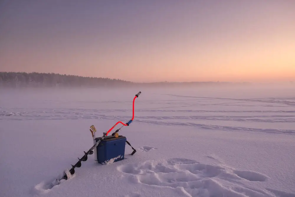 A fishing pole with a fishing line in the snow.