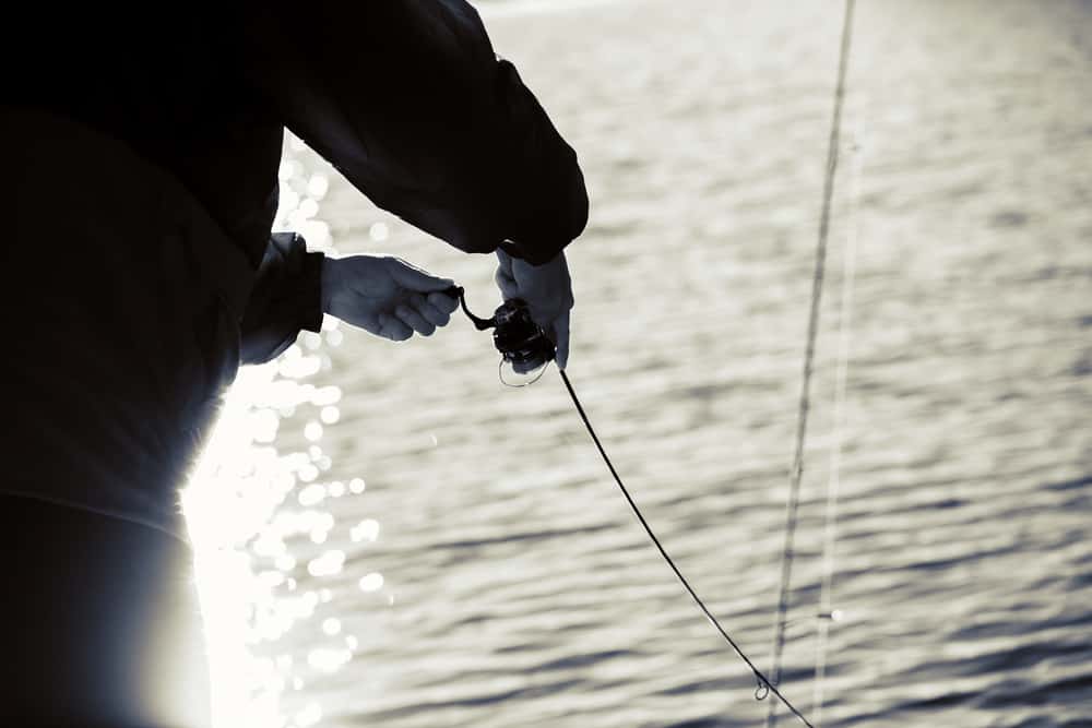 A person is holding a fishing line on a boat.